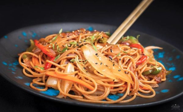 Wok vegano de spaghetti khorasan con verduras, soja y sésamo